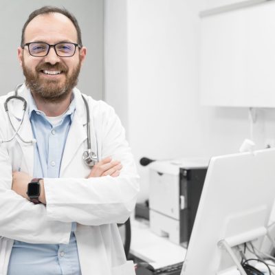 Portrait of confident doctor crossing hands and smiling at camera. High quality photography.